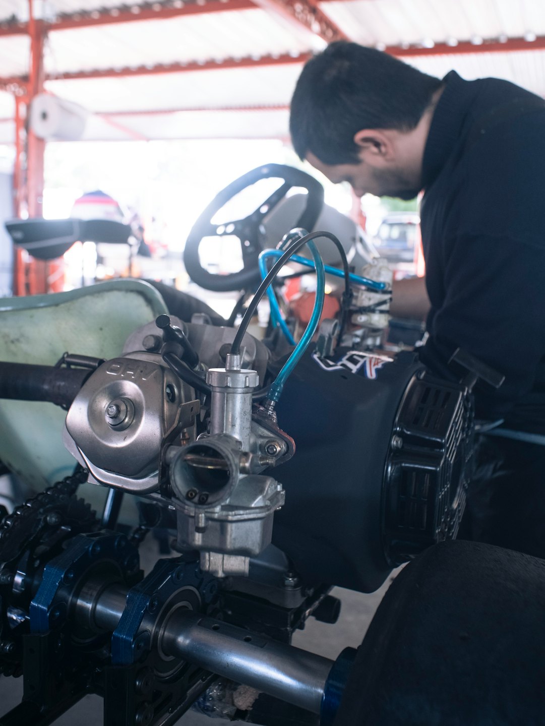 Mechanik pracuje na motore motokáry v dielni.