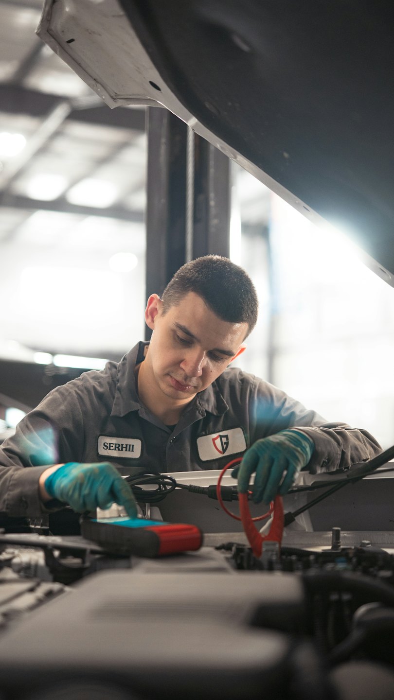 Mechanik používa diagnostický nástroj na motor autej v garáži.